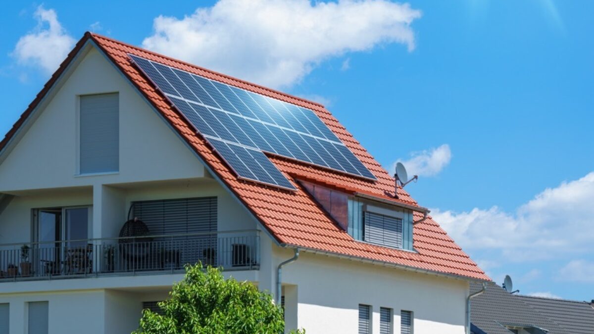 Home with solar energy green plants sunny blue sky groot